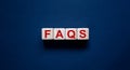 Concept word `FAQS` on cubes on a beautiful black background. Business concept, copy space