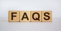 Concept word `FAQS` on cubes on a beautiful white background. Business concept, copy space