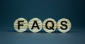 Concept word `FAQS, frequently asked questions` on wooden circles on a beautiful grey background. Business and FAQS concept