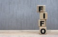 Concept of the word FIFO on cubes on a gray background