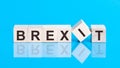 Concept word forming with cube on wooden desk background - Brexit. Blue background Royalty Free Stock Photo