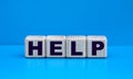 concept word HELP on cubes on a blue background Royalty Free Stock Photo