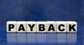 Concept word PAYBACK on cubes on a blue background