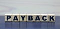 Concept word PAYBACK on wooden cubes on a beautiful background