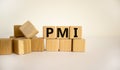 Concept word `PMI` - `Purchasing Managers Index` on wooden cubes on a beautiful white background. Business concept. Copy space