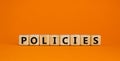Concept word `policies` on wooden cubes on a beautiful orange background. Business concept, copy space