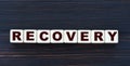 Concept word RECOVERY on cubes on a beautiful dark wooden background