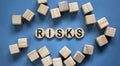 Concept word `risks` on woodwn circles on a beautiful blue background. Business concept