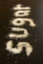 Concept word sugar written in sugar grains on black background Royalty Free Stock Photo