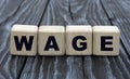 Concept word WAGE on cubes on a dark wooden background Royalty Free Stock Photo