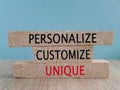 Concept words Personalize, customize, unique on brick blocks on a beautiful blue background. Wooden table. Business concept