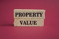 Concept words Property value on beautiful brick blocks. Beautiful wooden table blue background. Business property value concept.