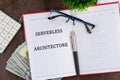 Concept words SERVERLESS ARCHITECTURE It is written in a business book in a composition with a calculator, a pen and dollar bills Royalty Free Stock Photo
