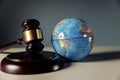 Concept of world justice. Wooden judge gavel and globe on the desk close-up Royalty Free Stock Photo