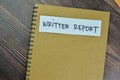 Concept of Written Report write on a book isolated on Wooden Table