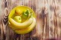 The concept of yellow on yellow. Yellow whole lemon, apples and bananas on a plate