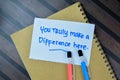Concept of You Trully Make a Difference Here write on sticky notes isolated on Wooden Table