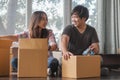 Concept couple moving house. Asian young couple make high five hands after finish packing cardboard box prepare for