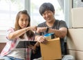 Concept young couple moving house. Asian young couple make fisk bump hands after finish packing cardboard box.