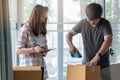 Concept young couple moving house. Asian young couple make high five hands after finish packing cardboard box.