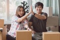 Concept young couple moving house. Asian young couple make high five hands after finish packing cardboard box prepare.