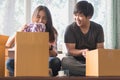 Concept young couple moving house. Asian young couple make high five hands after finish packing cardboard box.