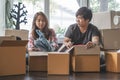 Asian young couple make high five hands after finish packing cardboard box prepare for