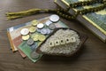 Concept of zakat in Islam religion. Selective focus of money, rosary beads, Quran and rice with alphabet of zakat on wooden