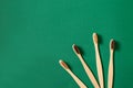 Top view or flat lay concept with eco bamboo tree toothbrushes on green background. Concept of zero waste and caring for Royalty Free Stock Photo