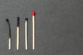 One unburned match with red head and several burned matches Royalty Free Stock Photo