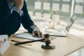 Concepts of justice and lawyers discuss contract paperwork with brass scales on a table with a judge`s hammer placed in front of l Royalty Free Stock Photo