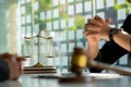 Concepts of justice and lawyers discuss contract paperwork with brass scales on a table with a judge`s hammer placed in front of l Royalty Free Stock Photo