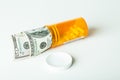 Concepts Money and Prescription Drugs in a container with a hundred dollar bill Royalty Free Stock Photo