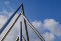 Triangular metal chrome pipes against deep blue sky. Royalty Free Stock Photo