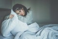 Portrait of depressed woman sitting alone on the bed in the bedroom. Royalty Free Stock Photo