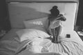 Portrait of depressed woman sitting alone on the bed in the bedroom / Black and White tone. Royalty Free Stock Photo