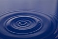 Conceptual blue liquid falling in water background with ripples and waves