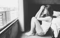 Portrait of depressed woman sitting alone on the floor in the bedroom. Royalty Free Stock Photo