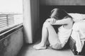 Portrait of depressed woman sitting alone on the floor in the bedroom. Royalty Free Stock Photo