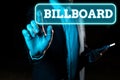 Conceptual caption Billboard. Word for act of furthering the growth or development of something Businessman Pointing