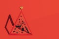 Conceptual Christmas tree with black accessories on red background Royalty Free Stock Photo