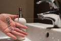 Conceptual close up shot of the left hand of a Caucasian man. On the palm there is the word covid-19, immediately next to the sink