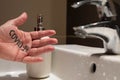 Conceptual close up shot of the left hand of a Caucasian man. On the palm there is the word covid-19, immediately next to the sink