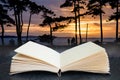 Conceptual composite open book image of Beautiful sunset silhouette of trees and sea in background and people walking Royalty Free Stock Photo