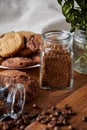 Conceptual composition with two jars of coffee beans, instant coffee and tasty cookies on wooden table, selective focus Royalty Free Stock Photo