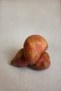 Conceptual creative still life with balancing fresh red potatoes on a light gray background.Trendy ugly organic unusual vegetables