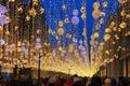 Conceptual defocused abstract Christmas decoration and crowd of people on city street at night