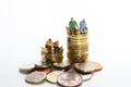 Miniture figure retired couple sat on a stack of pound coins