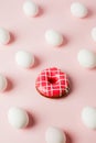 Conceptual easter egg background with pink donut on pink pastel background