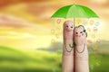 Conceptual easter finger art. Couple is holding green umbrella with falling easter eggs. Stock Image